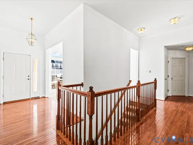 a view of a hallway with wooden floor and staircase