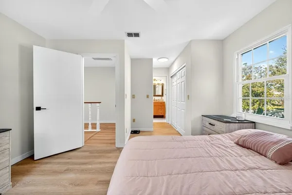 a bedroom with a large bed and wooden floor