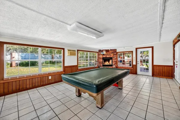 a room with pool table and windows