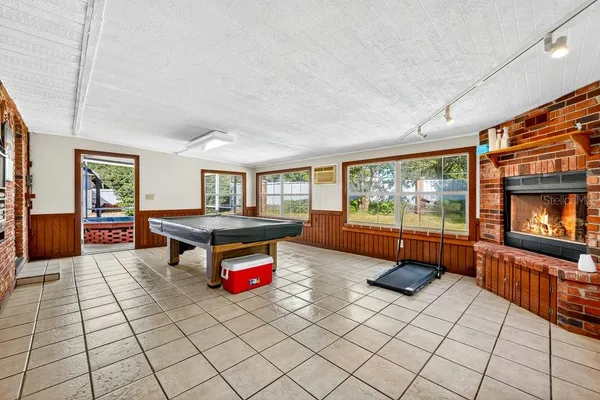 a living room with furniture a flat screen tv and floor to ceiling window