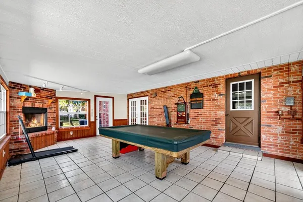 a living room with pool table and windows