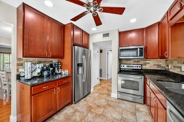 a kitchen with stainless steel appliances granite countertop a stove refrigerator sink and cabinets