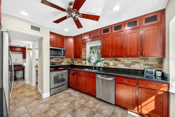 a kitchen with granite countertop stainless steel appliances and wooden cabinets