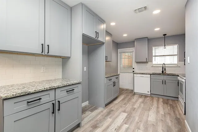 a kitchen with a sink window and stainless steel appliances