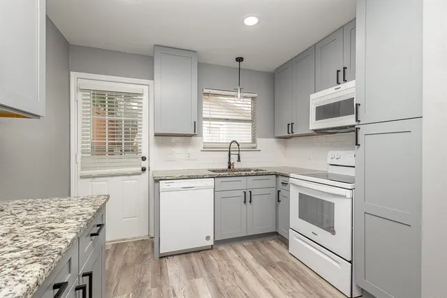 a kitchen with stainless steel appliances granite countertop a stove a sink and a microwave