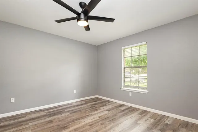 an empty room with a window and a fan