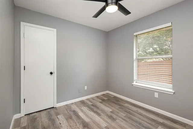 a view of empty room with window and ceiling fan