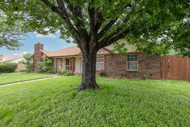 a view of a house with backyard and a tree