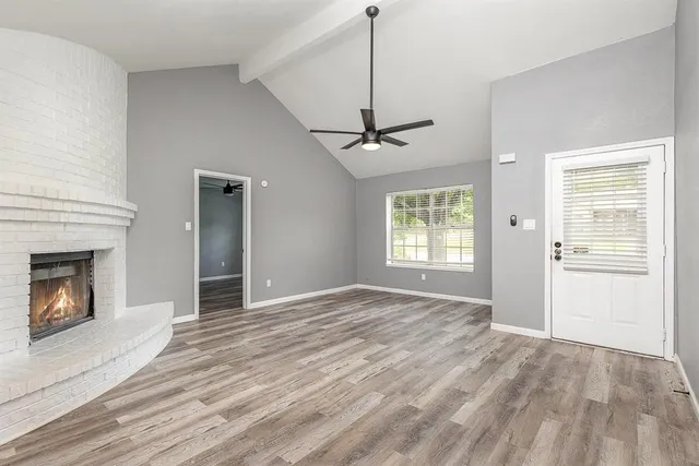a view of an empty room with a window and fireplace