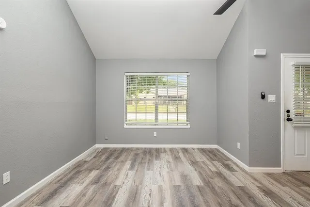 a view of a room with wooden floor and windows