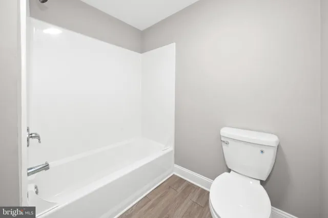 a bathroom with a granite countertop toilet and a sink