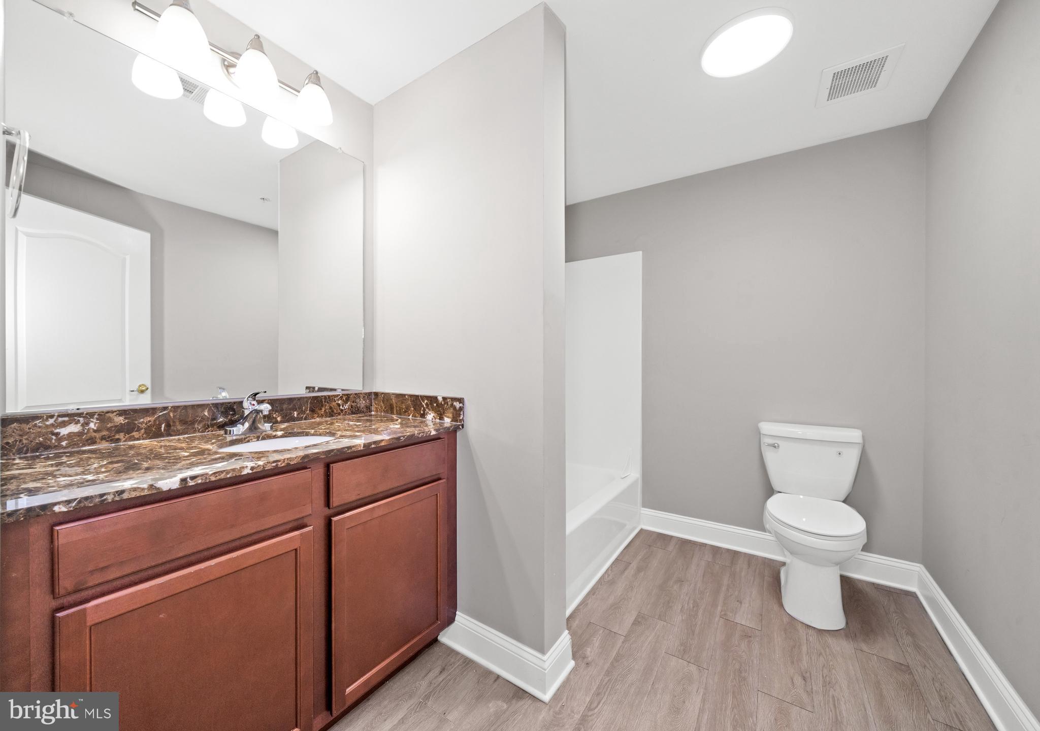 3000 Fountainview Circle, Unit 301 Newark, DE 19713 - Photo 13 of 17 a bathroom with a granite countertop toilet and a sink