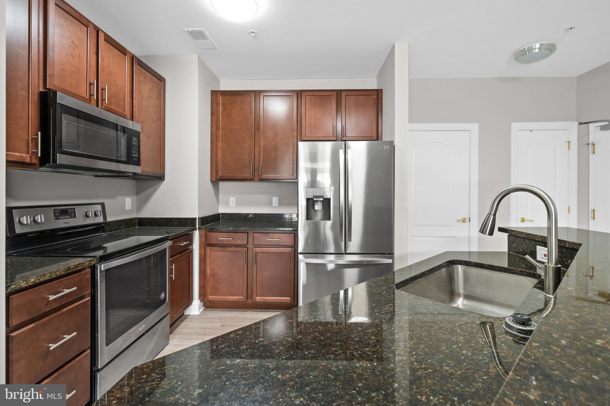 3000 Fountainview Circle, Unit 301 Newark, DE 19713 - Photo 8 of 17 a kitchen with stainless steel appliances granite countertop a refrigerator stove and microwave