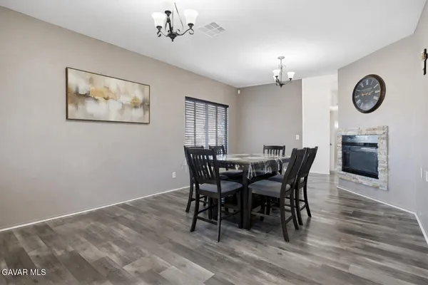 a view of a dining room with furniture a chandelier and wooden floor