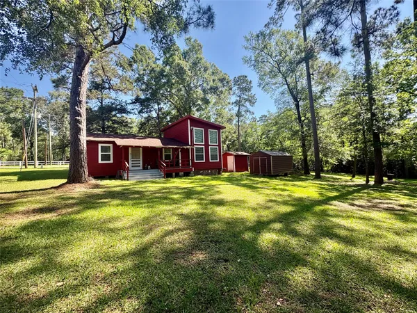 a view of a house with a yard patio and tree