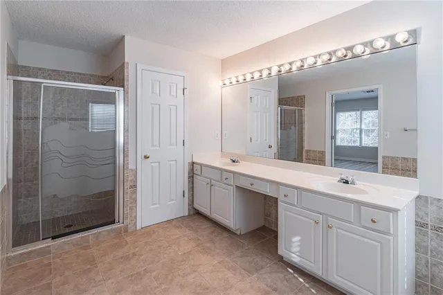 a spacious bathroom with a shower sink and mirror