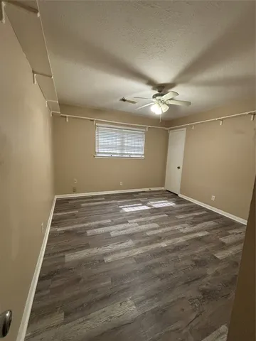 a view of a room with a ceiling fan and wooden floor
