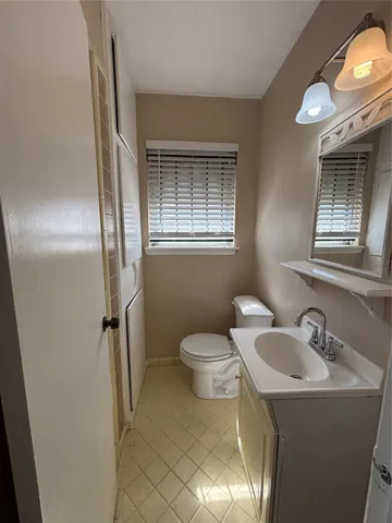 a bathroom with a toilet sink and mirror