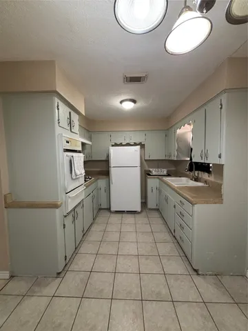 a kitchen with cabinets and white appliances