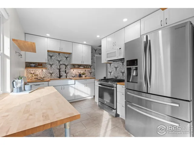 a kitchen with stainless steel appliances kitchen island granite countertop a refrigerator oven a sink and dishwasher