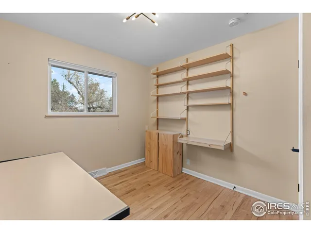 a view of empty room with wooden floor and cabinet