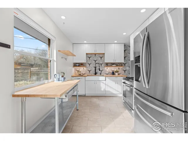 a kitchen with stainless steel appliances kitchen island a refrigerator sink and cabinets