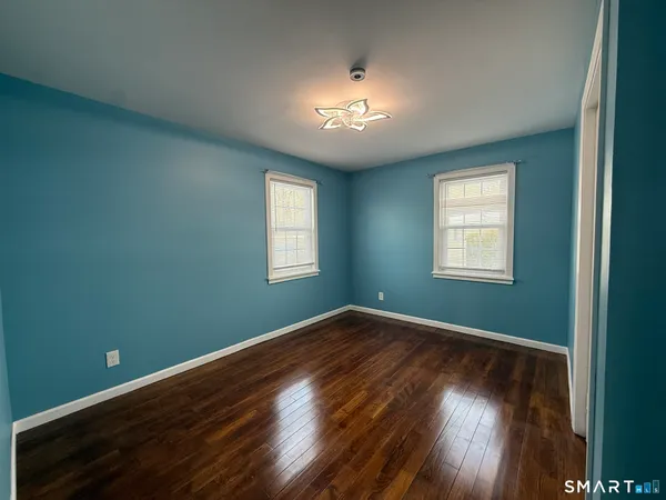 a view of a room with wooden floor and windows