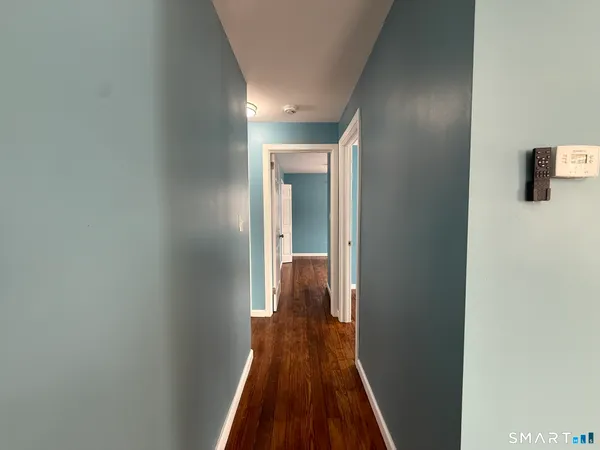 a view of a hallway with wooden floor