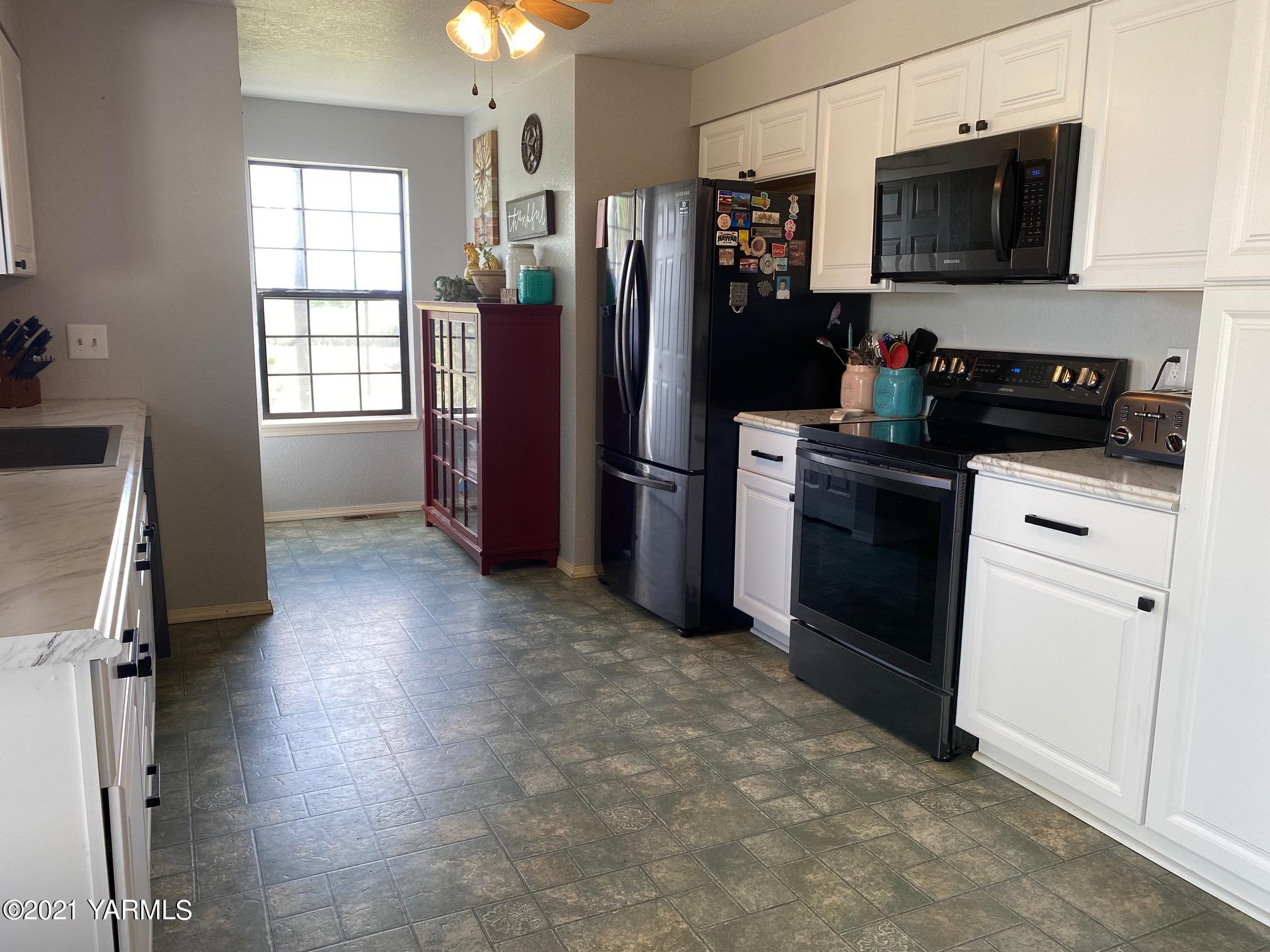 1260 Beffa Road Tieton, WA 98947 - Photo 11 of 38 a kitchen with stainless steel appliances granite countertop a refrigerator stove and microwave