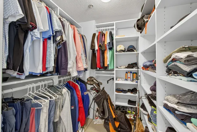 a view of walk in closet with clothes and shoes