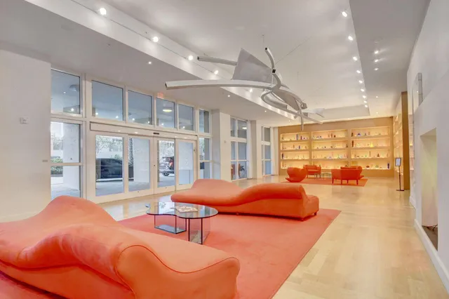 a spacious bedroom with a large bed and a chandelier