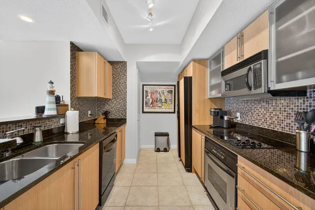 a kitchen with stainless steel appliances granite countertop a stove sink and cabinets