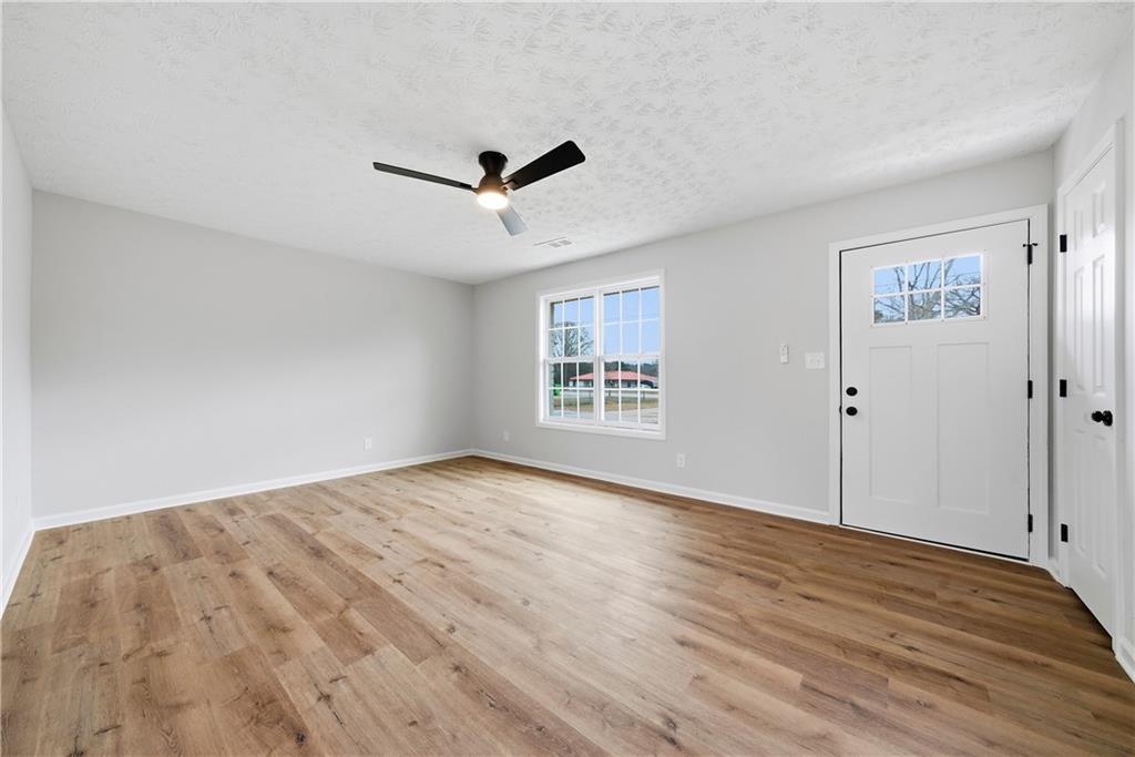 7258 Banks Mill Road Douglasville, GA 30135 - Photo 2 of 23 a view of empty room with wooden floor and ceiling fan