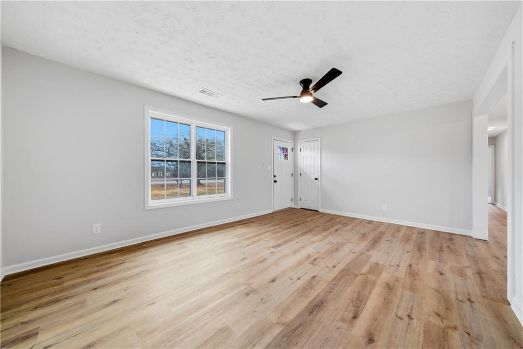 7258 Banks Mill Road Douglasville, GA 30135 - Photo 3 of 23 wooden floor in an empty room with a window