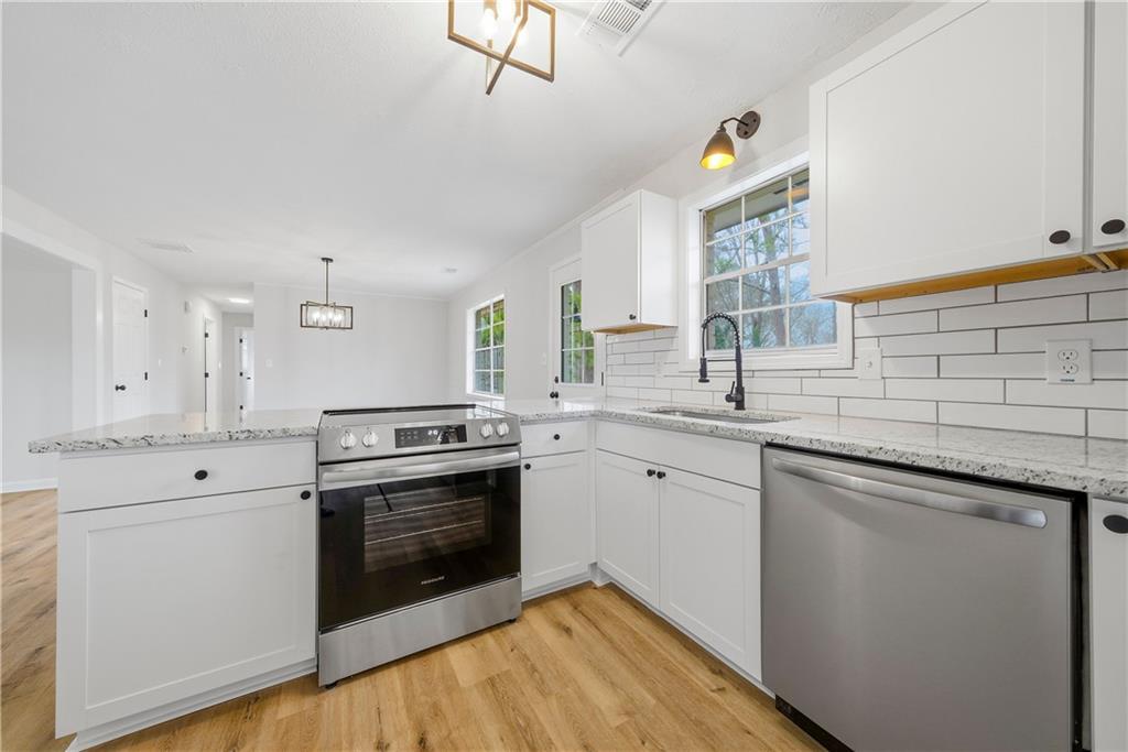 7258 Banks Mill Road Douglasville, GA 30135 - Photo 6 of 23 a kitchen with stainless steel appliances granite countertop a stove and a sink