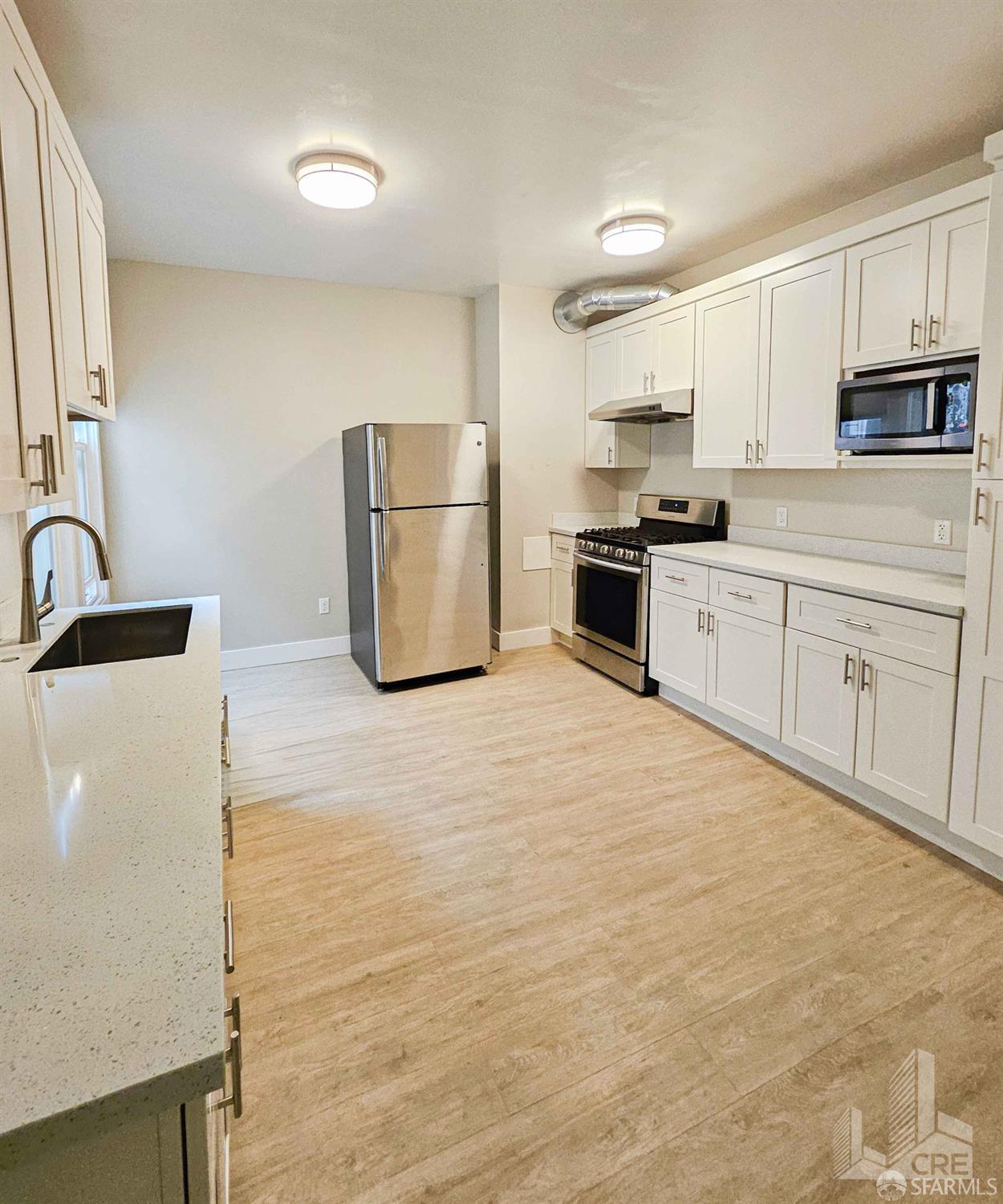 66-68 Moss Street San Francisco, CA 94103 - Photo 3 of 8 a kitchen with granite countertop a refrigerator stove top oven and sink