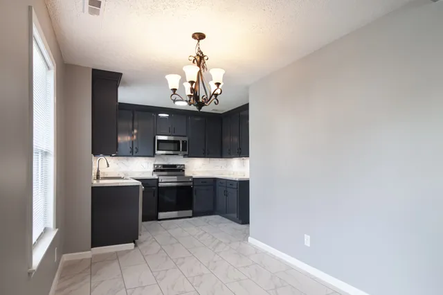 a view of kitchen with sink and stainless steel appliances