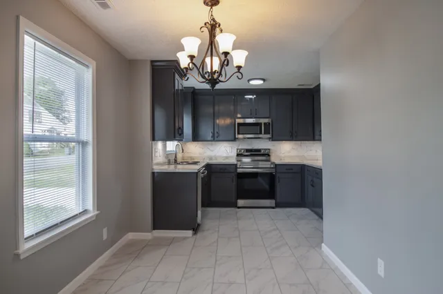 a kitchen with stainless steel appliances granite countertop a refrigerator and a sink