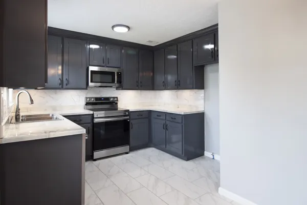 a kitchen with sink a microwave and cabinets