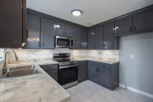 a kitchen with granite countertop stainless steel appliances and wooden cabinets