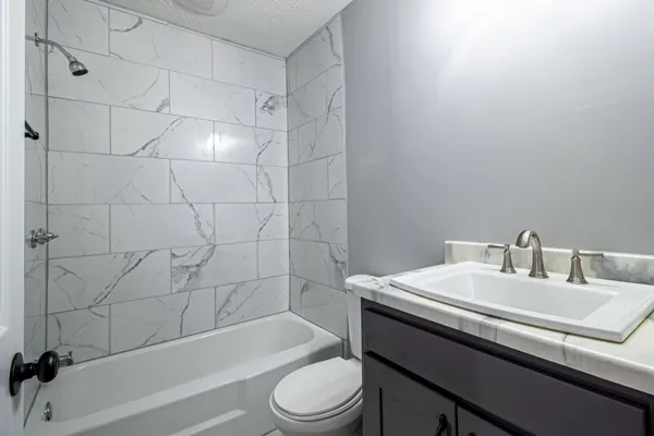 a bathroom with a sink toilet vanity and bathtub