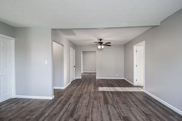 a view of empty room with wooden floor