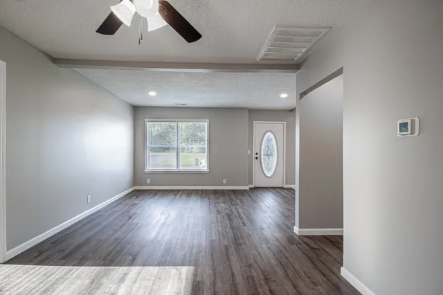 wooden floor in an empty room with a window
