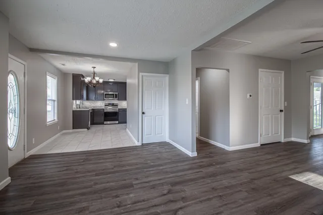 a view of a kitchen with wooden floor and a refrigerator