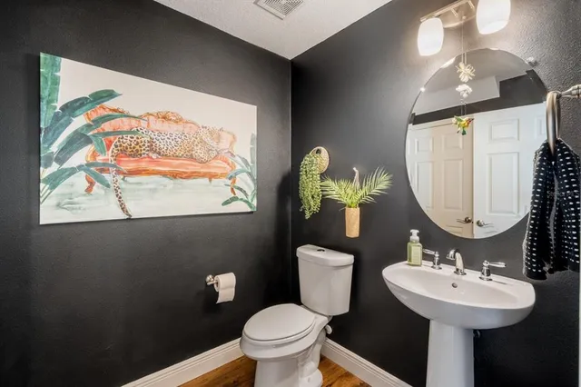a bathroom with a toilet sink and mirror