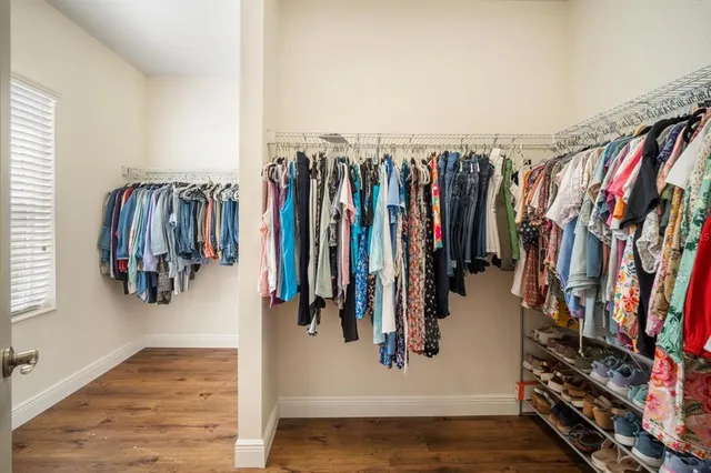 a view of walk in closet with clothes and shoes