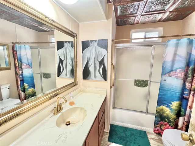 a bathroom with a sink and mirror with bathtub