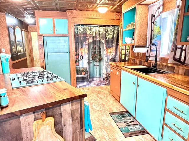 a kitchen with stainless steel appliances kitchen island granite countertop a refrigerator and a wooden cabinets