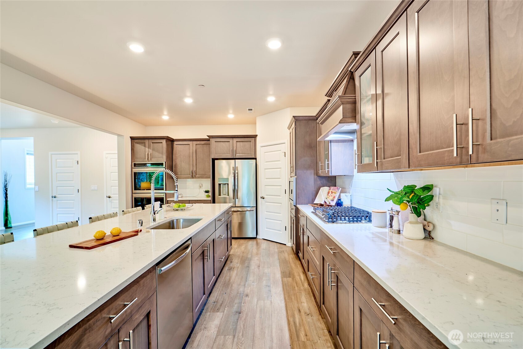 4022 233rd Street Southeast Bothell, WA 98021 - Photo 10 of 40 a large kitchen with stainless steel appliances a lot of counter space wooden floor and staircase