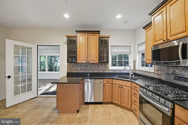 a kitchen with stainless steel appliances granite countertop a refrigerator and a sink